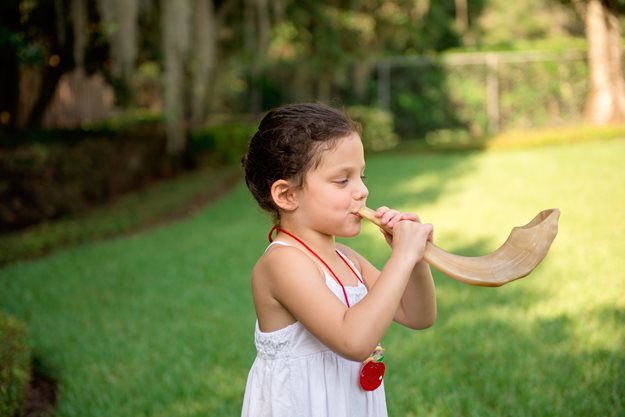 Little girl blowing shofar